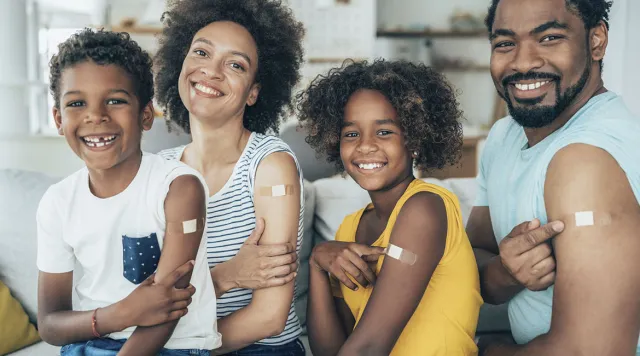 Smiling family with bandages on their upper arms