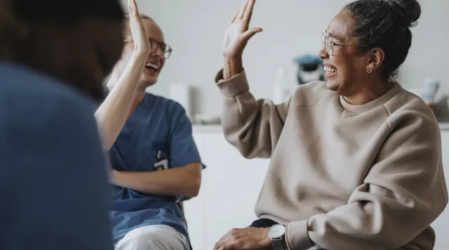 Two smiling people high five