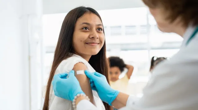 Hand places bandage on patient's arm